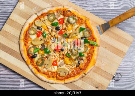 Pizza au jalapeno aux champignons de poulet coupée en huit morceaux. Pizza maison. Banque D'Images