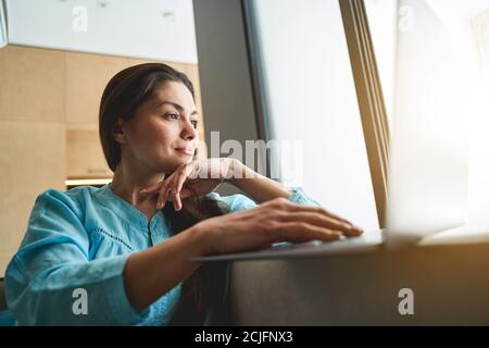 Charmante femme sereine freelance travaillant à la maison Banque D'Images