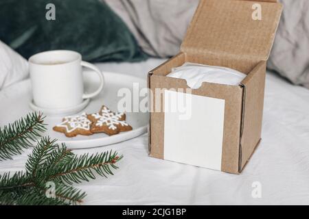 Scène de maquette de boîte-cadeau de Noël. Tasse de café, biscuits au pain d'épice et branches d'épinettes sur plaque en céramique. Arrière-plan de vacances. Petit déjeuner au lit Banque D'Images