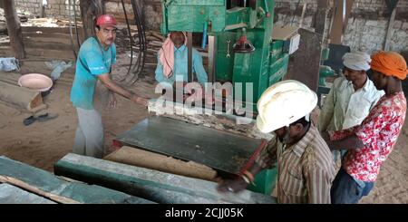 DISTRICT KATNI, INDE - 16 SEPTEMBRE 2019 : ouvrier indien du bois coupant des grumes de bois à partir de machines électriques sur le site de l'usine de sciage. Banque D'Images