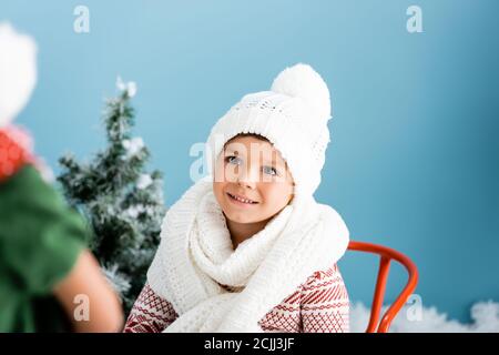 accent sélectif sur le garçon en écharpe tricotée et chapeau bleu Banque D'Images