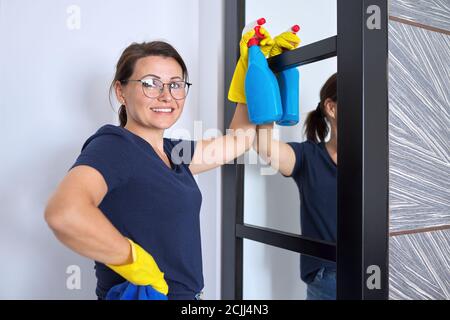 Nettoyage de maison, femme mature nettoie à la maison dans le salon Banque D'Images