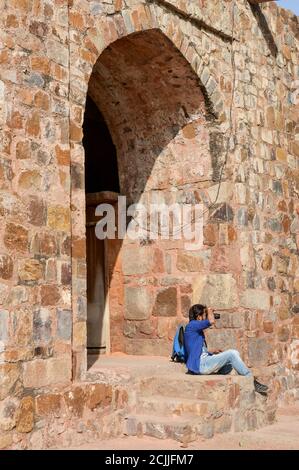 Un garçon indien qui se pose et clique sur une photo de l'ancien fort qui donne la pose pour une séance photo de mode. Banque D'Images