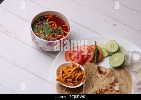 Dhaba style Sev bhaji/sabzi/curry fait en curry de tomate avec gathiya shev, servi avec chapati/ roti. Banque D'Images