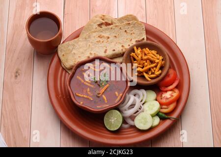 Dhaba style Sev bhaji/sabzi/curry fait en curry de tomate avec gathiya shev, servi avec chapati/ roti. Banque D'Images