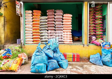 Gros plan d'un magasin aux Philippines qui vend exclusivement des marques et des qualités différentes de riz. Les sacs de riz sont empilés dans un lieu de stockage ouvert Banque D'Images