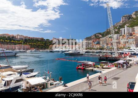 Monte Carlo, Monaco - 15 août 2018 : bateaux à moteur et yachts de plaisance amarrés à Port Hercule de Monte Carlo. Les touristes marchent dans la rue à proximité Banque D'Images