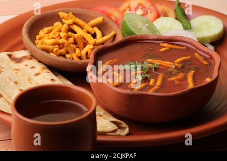 Dhaba style Sev bhaji/sabzi/curry fait en curry de tomate avec gathiya shev, servi avec chapati/ roti. Banque D'Images