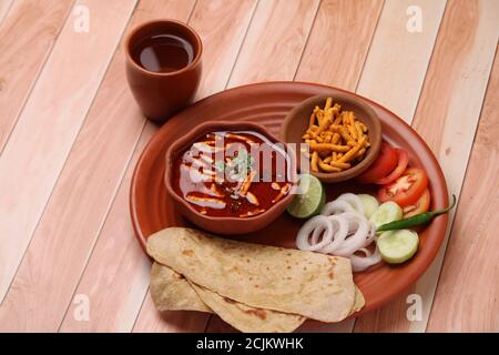 Dhaba style Sev bhaji/sabzi/curry fait en curry de tomate avec gathiya shev, servi avec chapati/ roti. Banque D'Images