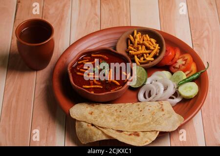 Dhaba style Sev bhaji/sabzi/curry fait en curry de tomate avec gathiya shev, servi avec chapati/ roti. Banque D'Images