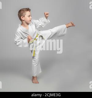 enfant pratiquant le karaté en position de kick. studio shot. Banque D'Images