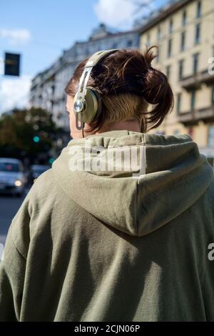 Fille dans la rue de Milan portant des écouteurs Banque D'Images