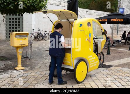 La poste France, une Société postale française - une femme postier collectant les lettres et le courrier d'une boîte aux lettres avec son tricycle, Amboise France Europe Banque D'Images