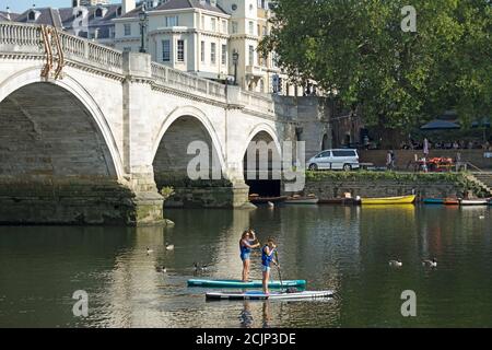 deux planchistes femelles sur la tamise, près du pont de richmond, dans le sud-ouest de londres, en angleterre Banque D'Images