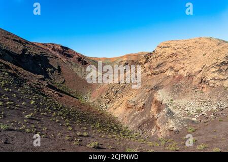 Vue panoramique unique de spectaculaires couches de lave corrodées de l'immense cône du volcan. Parc des volcans de Timanfaya, Lanzarote, îles Canaries, Espagne. Banque D'Images