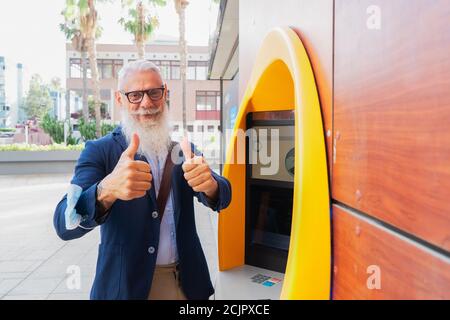 Homme senior avec ATM Banque D'Images