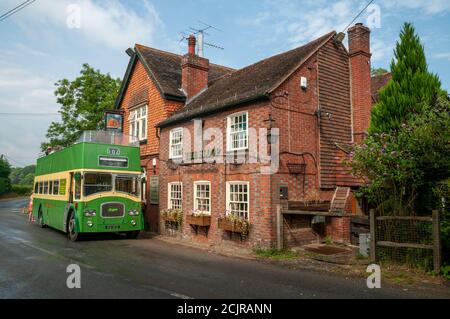 Le Sloop Inn pub avec un vieux bus vert à impériale, garé à l'extérieur près de Scaynes Hill, West Sussex, Royaume-Uni Banque D'Images