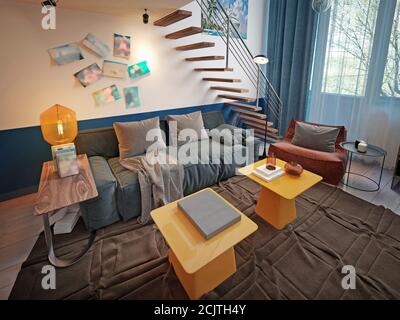 Design d'une chambre d'adolescent avec un canapé bleu tendance et deux tables de créateur jaunes. rendu 3d Banque D'Images