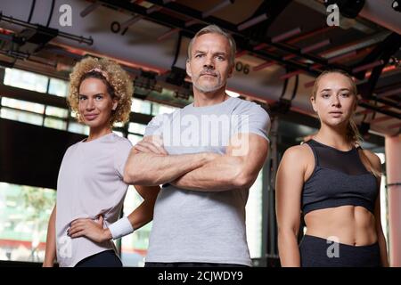 Portrait d'un groupe de personnes en bonne santé debout et regardant appareil photo dans la salle de gym Banque D'Images