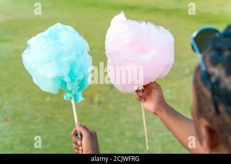 Un heureux couple noir ayant des bonbons colorés soie ensemble dans un parc d'une grande ville. Banque D'Images