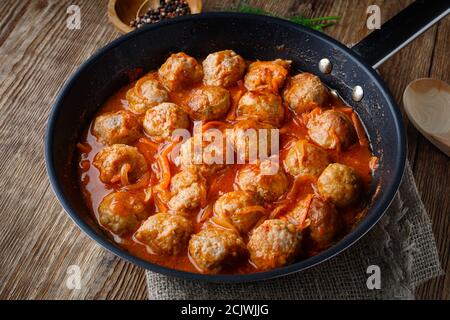 Boulettes de viande dans une casserole de sauce tomate aigre et douce Banque D'Images