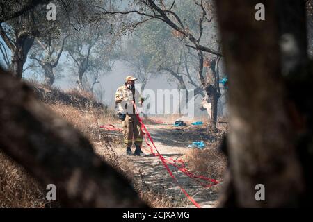 Un pompier combat les flammes au camp de réfugiés de Moria en Grèce. Des milliers de personnes ont été contraintes de fuir leur foyer après qu'un incendie a éclaté dans le camp de Moria, détruisant leurs maisons et leurs biens. Banque D'Images