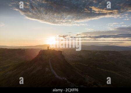 Vue aérienne de la ville en pierre de Civita di Bagnoregio avec le soleil au lever du soleil avec des badomes en argile et des arbres arrière-plan Banque D'Images