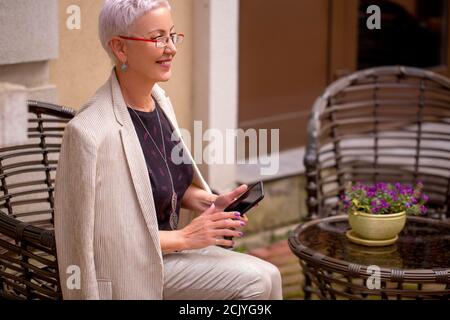 une femme d'affaires atractie attend ses clients au café extérieur. réunion dans un cadre informel. photo avec vue latérale. concept attente Banque D'Images