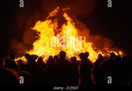 Personnes en silhouette debout devant un grand feu de joie lors des célébrations annuelles de la nuit Guy Fawkes & Bonfire à Littlehampton, West Sussex, Royaume-Uni. Banque D'Images