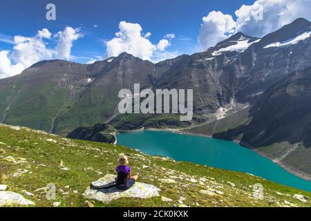 Petite fille assise et profitant de la vue magnifique sur le lac de haute montagne Près de Kaprun, Autriche.calme détente en plein air.merveilleux paysage de la nature, turquoise wate Banque D'Images