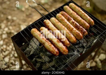 Gros plan vue de dessus photo de la préparation de saucisses délicieuses sur barbecue grill.nourriture savoureuse, repos, tourisme, concept de vacances. Banque D'Images