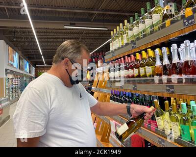 Orlando,FL/USA -8/6/20: Un homme regardant une bouteille de vin dans l'allée des vins d'une épicerie Aldi à Orlando, Floride. Banque D'Images