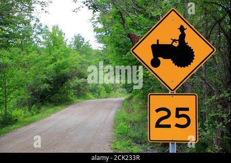 Passage d'un tracteur jaune et indication de limite de vitesse par un pays Route près de Londonderry.Vermont.USA Banque D'Images