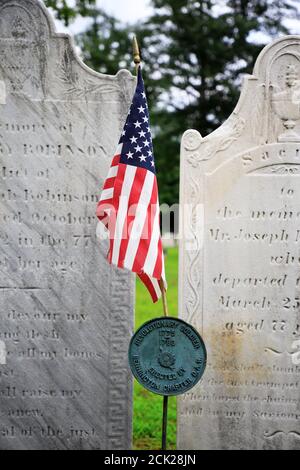 La plaque indiquant la tombe du soldat révolutionnaire américain surmontée Un drapeau américain devant les pierres tombales.Old Bennington Cemetery.Bennington.Vermont.USA Banque D'Images