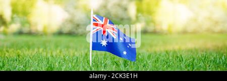 Drapeau australien sur l'herbe verte. Fête nationale de l'Australie. Nature pays citoyenneté arrière-plan extérieur. En-tête de bannière Web. Banque D'Images