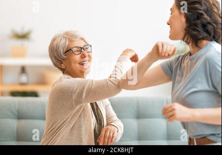 Belle mère et fille font un nouvel accueil pour éviter la propagation du coronavirus à la maison. Bosse du coude. Banque D'Images