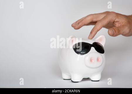 investir dans un sac de financement pour une vie future bonne. main tenant une banque de piggy pièces de fond blanc Banque D'Images