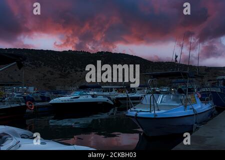 Coucher de soleil à Balaklava Crimée le 04 septembre 2020. Navires dans la soirée dans la baie de Balaklava. Crépuscule paysage urbain nuageux. Bateaux de plaisance dans le Banque D'Images