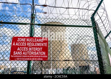 Vue rapprochée d'un panneau d'avertissement sur la clôture de sécurité avec fil barbelé d'une centrale nucléaire en France. Banque D'Images