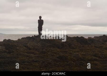 La sculpture d'Anthony Gormley S'ACCROCHE à Saddell Bay, Kintyre, Argyll, en Écosse, sur des rochers qui ont vue sur le détroit de Kilbannan jusqu'à l'île d'Arran Banque D'Images