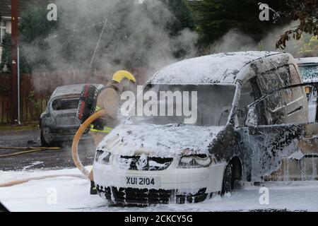 Belfast, Irlande du Nord, Royaume-Uni. 15 septembre 2020. Le Service d'incendie et de sauvetage d'Irlande du Nord a mis deux voitures à l'arrêt à l'arrière des maisons dans le secteur de Rossnareen Avenue à l'ouest de Belfast. Voiture où abandonner des moments plus tôt.Credit: Paul McErlane Banque D'Images
