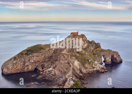 Vue complète du sanctuaire de San Juan de Gaztelugatxe avec un ciel clair montrant l'horizon Banque D'Images