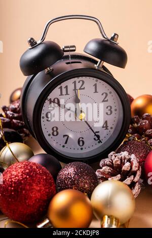 Focus sélectif. Horloge du nouvel an avec des mains de dix à douze. Avec des boules en plastique de Noël et des jouets de Noël Banque D'Images