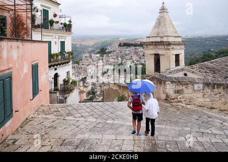 Couple de visite dans la pluie autour de la ville historique de Ragusa en Sicile, Italie Banque D'Images