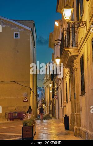 Vieille rue étroite illuminée de Mahon la nuit - Minorque, Espagne Banque D'Images