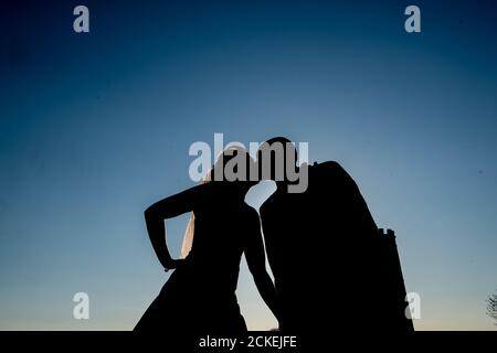 Silhouette de deux personnes embrassant et tenant les mains Banque D'Images