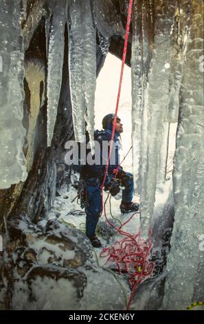 Un homme escalade sur glace sur Beck Low Water sur Coniston Old Man, Lake District, Royaume-Uni. Banque D'Images