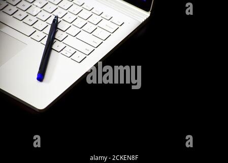 gros plan d'un stylet reposant sur le clavier de l'ordinateur portable arrière-plan noir Banque D'Images