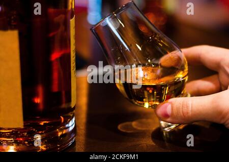 homme qui goûte un seul whisky de malt du verre de whisky glencairn Banque D'Images