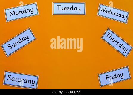 Concept d'éducation flatlay avec copyspace sur fond jaune, avec les jours de la semaine. Banque D'Images